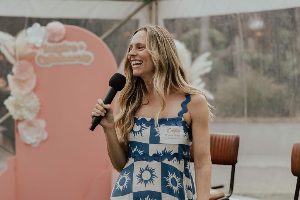 Brooke speaking on stage with a microphone